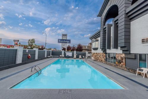 a large swimming pool on the roof of a building at Travelodge by Wyndham Calgary South in Calgary