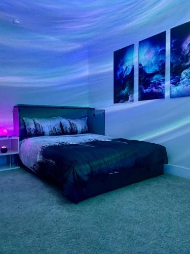 a bedroom with a bed with three pictures on the wall at Tapin7 Oasis in Durham