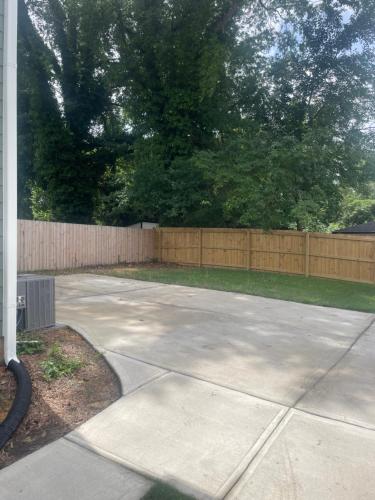 a concrete driveway in front of a fence at Tapin7 Oasis in Durham