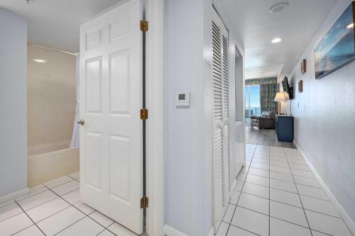 a hallway with a white door and a white tile floor at Luxury 17th Floor 1 BR Condo Direct Oceanfront Wyndham Ocean Walk Resort Daytona Beach | 1708 in Daytona Beach