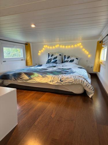 une chambre avec un grand lit dans une pièce dans l'établissement La Tiny du Rougy, à Frolois