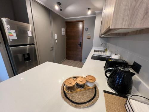 a kitchen with a counter with three jars on it at Acogedor céntrico full departamento condominio origen nuevo en pucón in Pucón