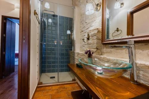 ein Badezimmer mit einem Glaswaschbecken und einer Dusche in der Unterkunft Casa del Estanco, casa rural in Salteras