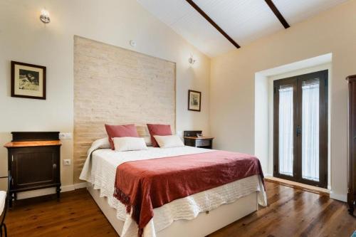ein Schlafzimmer mit einem großen Bett mit einer roten Decke in der Unterkunft Casa del Estanco, casa rural in Salteras