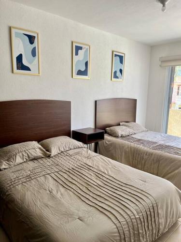 a bedroom with two beds and a window at Villa Sol Terrasol Acapulco Diamante in Acapulco