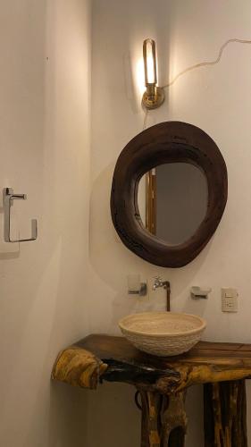 Un baño con lavabo de madera y espejo. en Dada, en Brisas de Zicatela