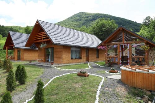 a log cabin in the mountains with a yard at Cabana Izvorul Rece Maramureş in Baia-Sprie