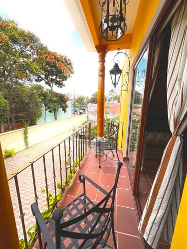 a porch with two chairs and a balcony with a view at Hotel Jotam in Panajachel