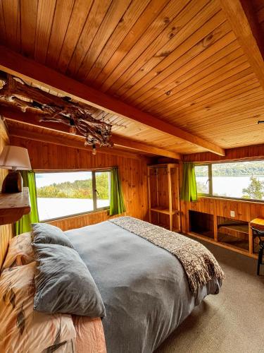 a bedroom with a large bed in a log cabin at Patagonia Nativa in Cochamó