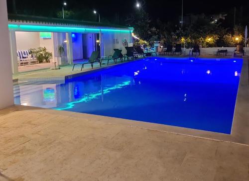a swimming pool at night with blue water at Hotel Alcaide in Portimão