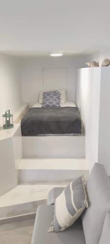 a white bedroom with a bed and a couch at Studio18 in Márpissa