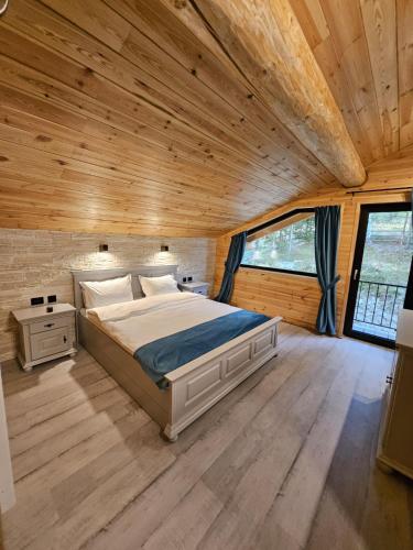 a bed in a room with a wooden ceiling at Cabana Delena in Vatra Dornei