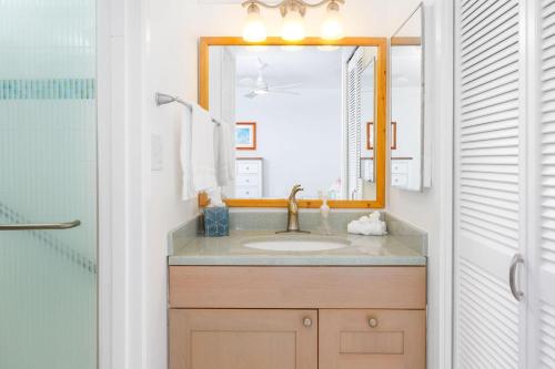 a bathroom with a sink and a mirror at Kona Alii 602 in Kailua-Kona