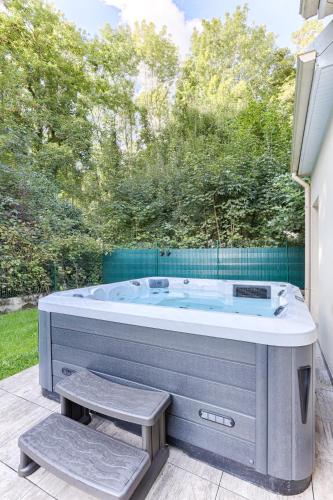 une baignoire jacuzzi assise sur un patio arboré dans l'établissement La Maison Pasteque - A 10 minutes de Disneyland, à Montévrain