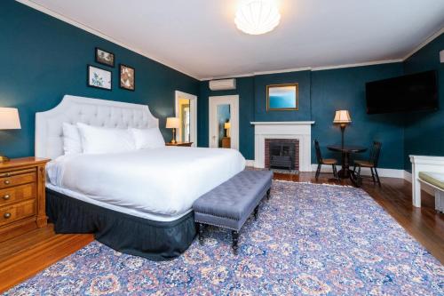 a bedroom with a large white bed and a fireplace at The Constance by The Lenox Collection in Lenox