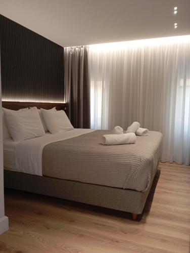 a bedroom with a bed with two towels on it at Kantoni Suites in Corfu Town