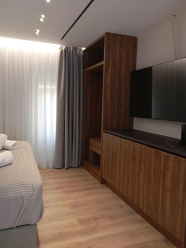a bedroom with a bed and a flat screen tv at Kantoni Suites in Corfu Town
