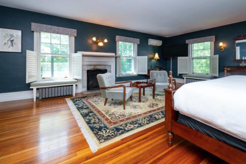a bedroom with a bed and a desk and a fireplace at The Constance by The Lenox Collection in Lenox