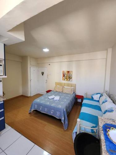 a large room with a bed and a couch at Studio no centro in Poços de Caldas