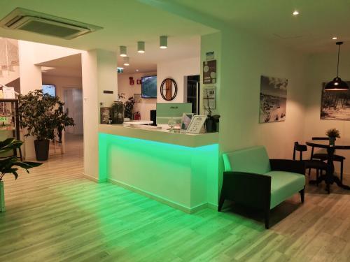 a waiting room with a green counter and a chair at Hotel Alcaide in Portimão