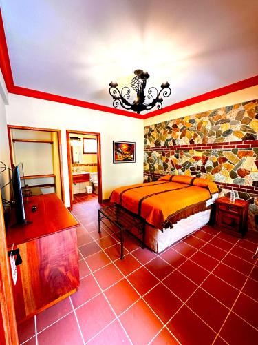 a bedroom with a king sized bed and a tv at Hotel Jotam in Panajachel
