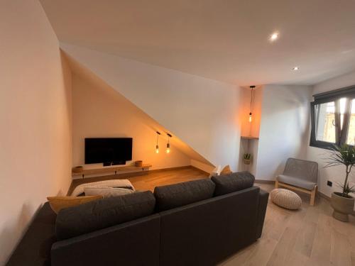 a living room with a couch and a tv at Apartamento Peña in Sardina