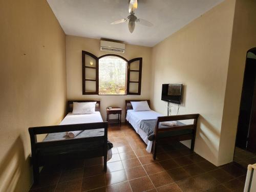 a room with two beds and a window at Pousada Recanto da Ladeira in Paraty