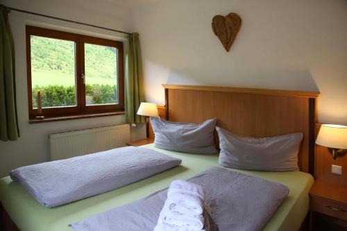 a bedroom with two beds and a window at Die Filzmooserin - Apartments in Filzmoos, Filzmoos Card inklusive in Filzmoos