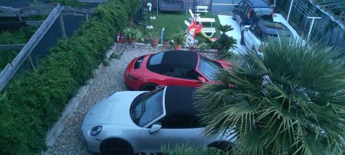 two cars parked in a parking lot with palm trees at DREAM HOUSE Casa Vacanze in Arma di Taggia