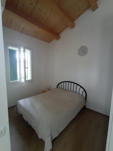 a bed in a white room with a window at Da Zia Vecchia in Cervia