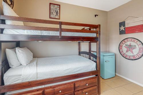 a bedroom with two bunk beds and a clock at Star Beachside Condominiums 106 in South Padre Island