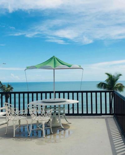a table and chairs on a balcony with an umbrella at Ponta Negra Suites & Apart in Natal