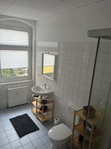 ein weißes Badezimmer mit Toilette und Waschbecken in der Unterkunft MH Apartments in Erfurt