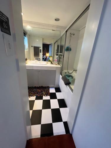 a bathroom with a black and white checkered floor at Seaside Getaway @ Swallow House Suite #2 in Cape Town