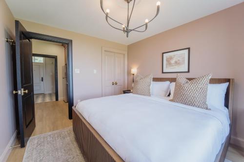 a bedroom with a large bed and a chandelier at The Penrose Suites in Saint Marys
