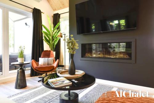 sala de estar con mesa de centro y chimenea en Le Scandinave - Détente avec Sauna et Spa privé, en Sainte-Catherine