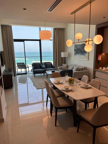 a dining room and living room with a table and chairs at Address Residence Bahrain in Rayyā