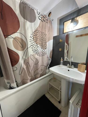une salle de bain avec un rideau de douche et un lavabo dans l'établissement Chaleureux Studio Montagnard avec balcon 2303, à Prémanon