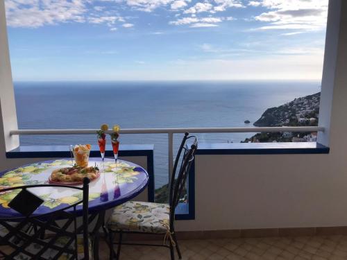 a balcony with a table and a view of the ocean at Da Nonna Nicoletta in Furore