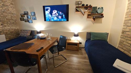 a room with a desk and a bed and a table at Magiczne Mieszkanko in Piła