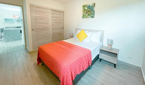 a bedroom with a bed with a red and orange blanket at Sanctuary by Playa Caracol Residences in Punta Chame