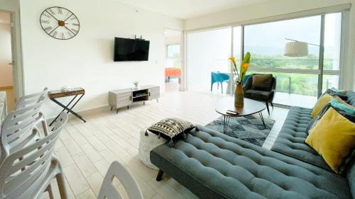 a living room with a couch and a clock on the wall at Sanctuary by Playa Caracol Residences in Punta Chame