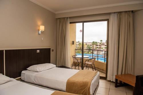 a hotel room with two beds and a balcony at Rosa Agustina Conference Resort in Olmué