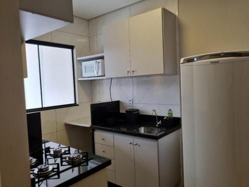 a small kitchen with a sink and a stove at 1- ACHEI Casa - Seu espaço preferido em Porto Velho in Porto Velho