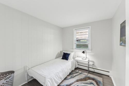 a white bedroom with a bed and a window at Pine Brook 416 I Corporate 15Br Apartment ! Pool in Newark