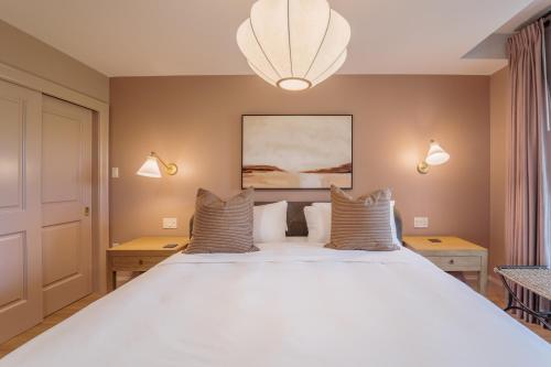 a bedroom with a large white bed with pillows at The Penrose Suites in Saint Marys