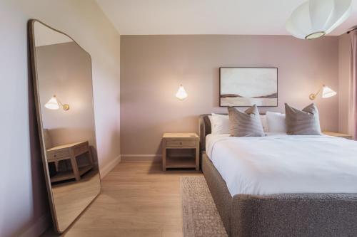 a bedroom with a large bed and a mirror at The Penrose Suites in Saint Marys