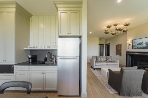 a kitchen with a refrigerator and a living room at The Penrose Suites in Saint Marys