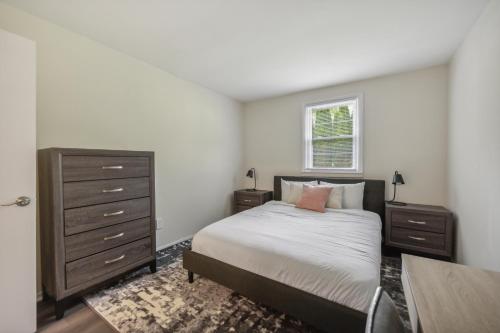a bedroom with a bed and a dresser and a window at Pine Brook 816 I Corporate 2Br Apartment ! in Newark