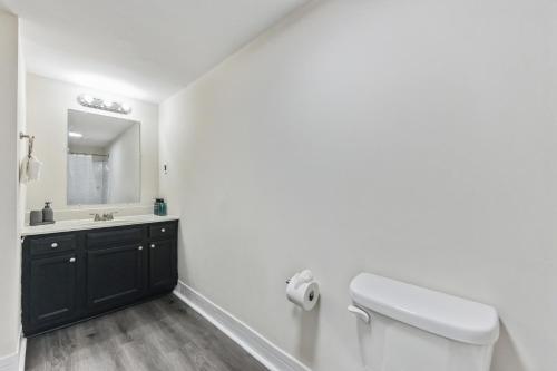 a white bathroom with a toilet and a sink at Pine Brook 816 I Corporate 2Br Apartment ! in Newark